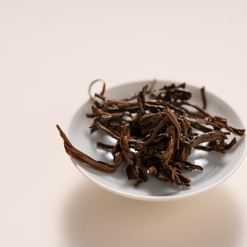 Tea leaves on a white plate with a plain background